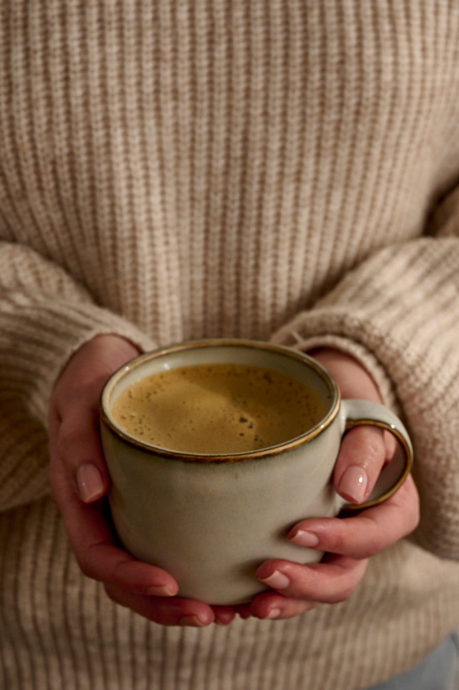 Woman holding warm cup of coffee alternative